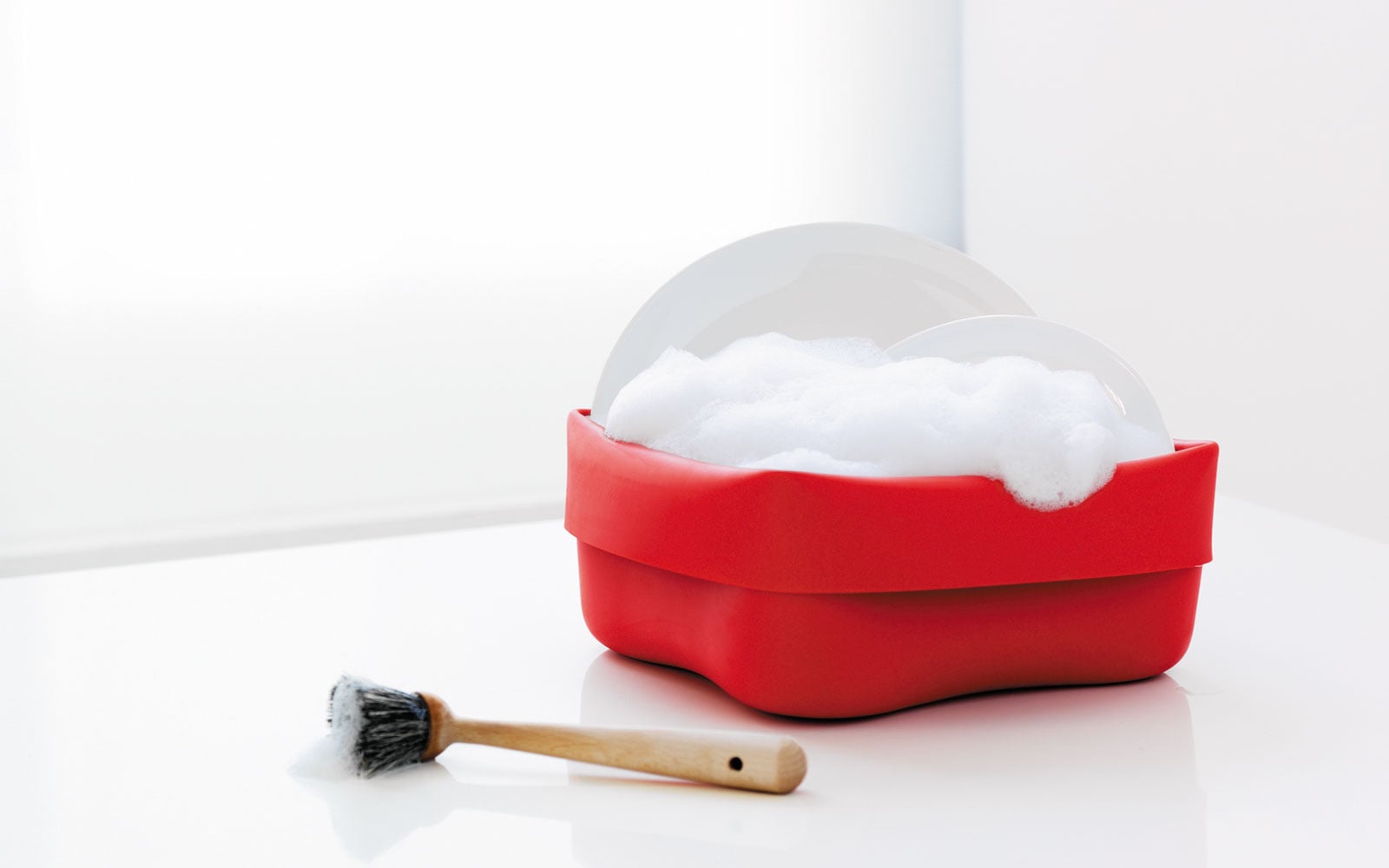 Washing up bowl red action function with dishes in a room background